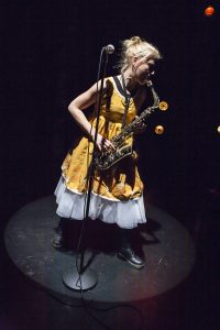 Kädettömät – Käsist seotud Lahden kaupunginteatterissa. Kuvassa näyttelijä Anna Lipponen soittaa saksofonia.